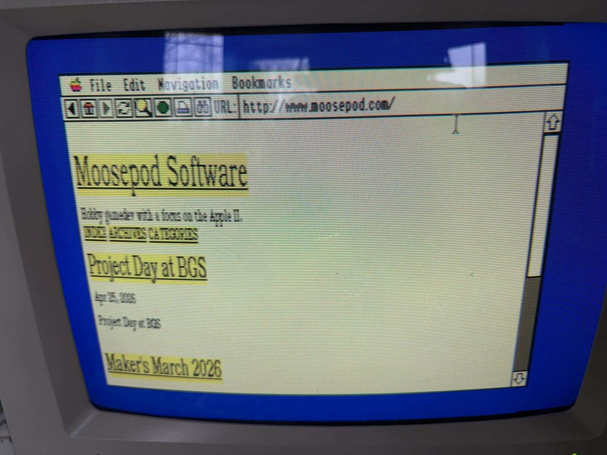 Photo of an Apple IIGS CRT displaying a page of moosepod.com